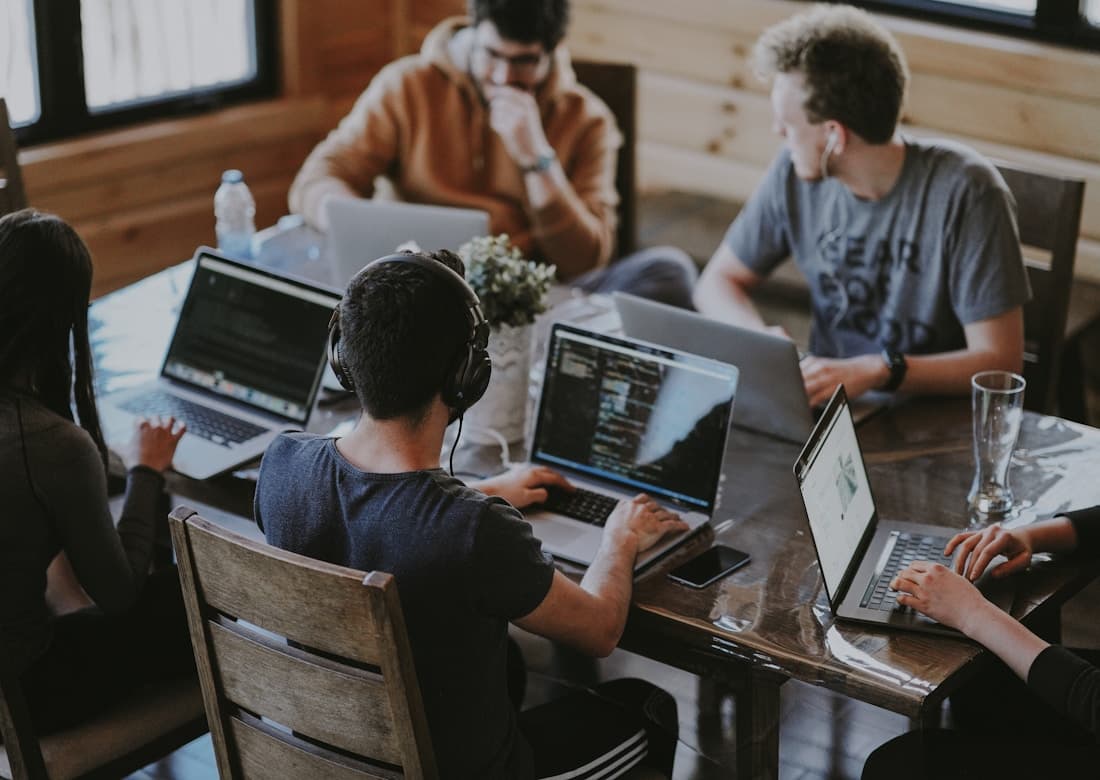 Team collaborating around laptops in an office